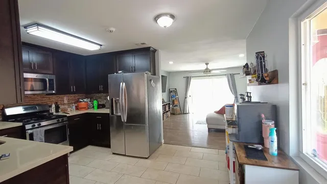 a kitchen with stainless steel appliances granite countertop a refrigerator and a stove top oven