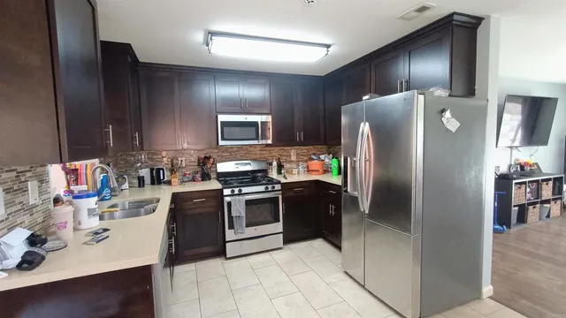 a kitchen with stainless steel appliances granite countertop a refrigerator stove and oven
