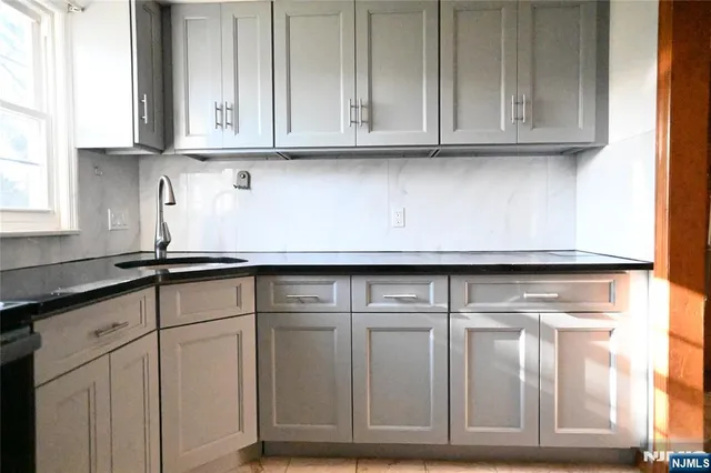 a kitchen with white cabinets and a sink