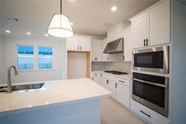 a kitchen with kitchen island granite countertop a stove and a center island