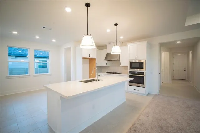 a large kitchen with a refrigerator a sink dishwasher a oven and a large window