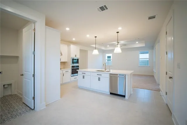 a view of an empty room with a kitchen
