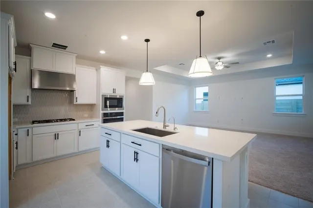 a kitchen with a sink dishwasher a stove and a refrigerator with wooden floor
