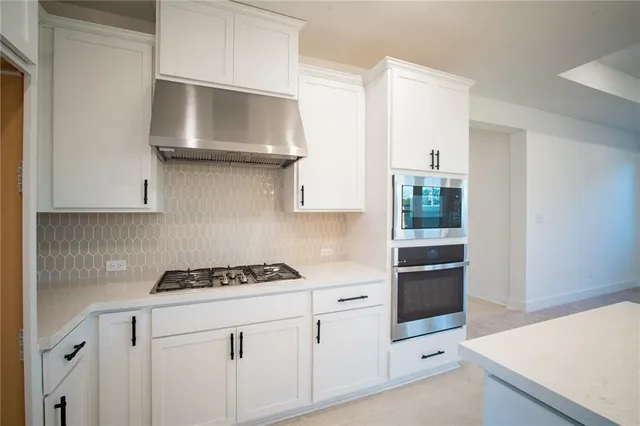 a large kitchen with kitchen island a stove a sink a center island a stove and a window