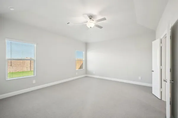 an empty room with a window and a fan