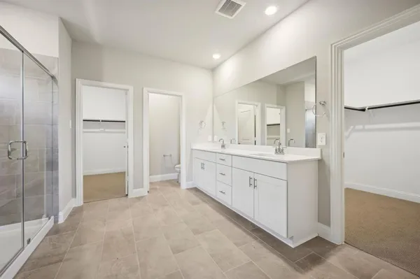 a spacious bathroom with a double vanity sink mirror and shower