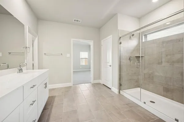a bathroom with a shower sink and mirror