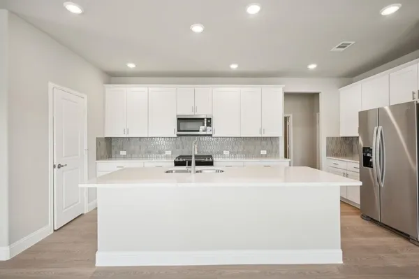 a white kitchen with refrigerator sink and cabinets