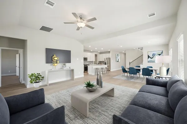 a living room with furniture and view of kitchen