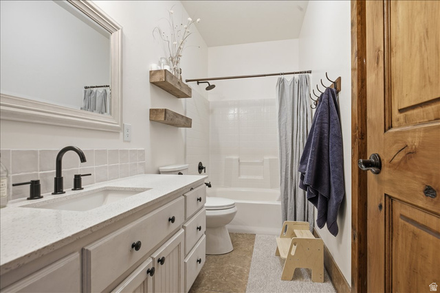 1634 West Arimo Road Arimo, ID 83214 - Photo 19 of 89 Bathroom featuring a light-colored vanity with a built-in sink and matte black faucet, a framed mirror, a tiled shower/tub combination, and a wood-finish door