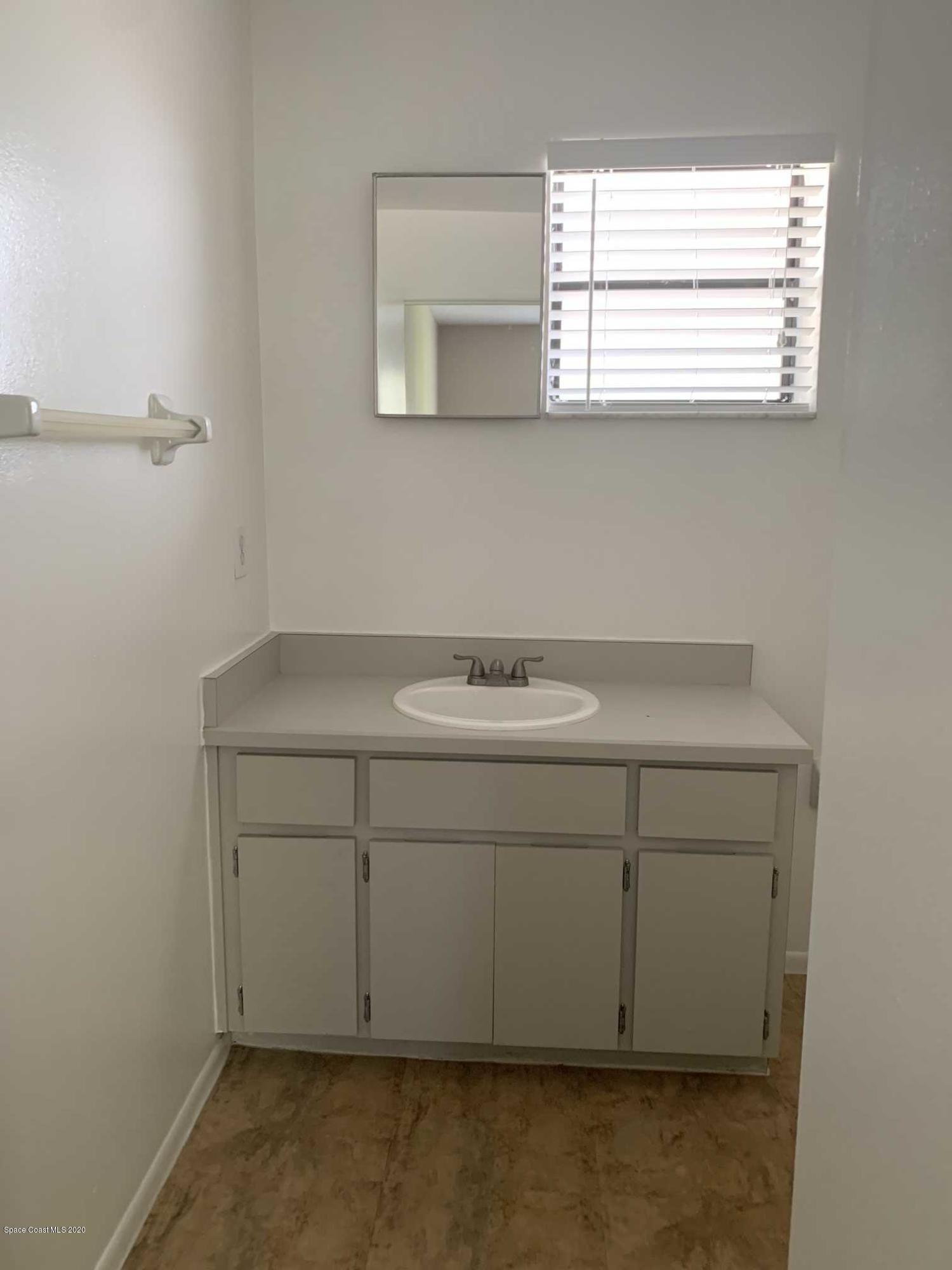 2222 Flower Tree Circle Melbourne, FL 32935 - Photo 13 of 17 a bathroom with a sink cabinets and a window