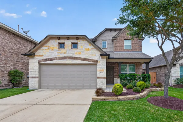 a front view of a house with a yard and garage