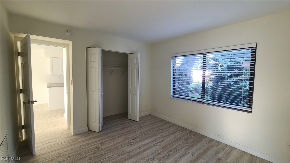 2610 Providence Street, Unit 1 Fort Myers, FL 33916 - Photo 12 of 16 a view of an empty room with wooden floor and a window