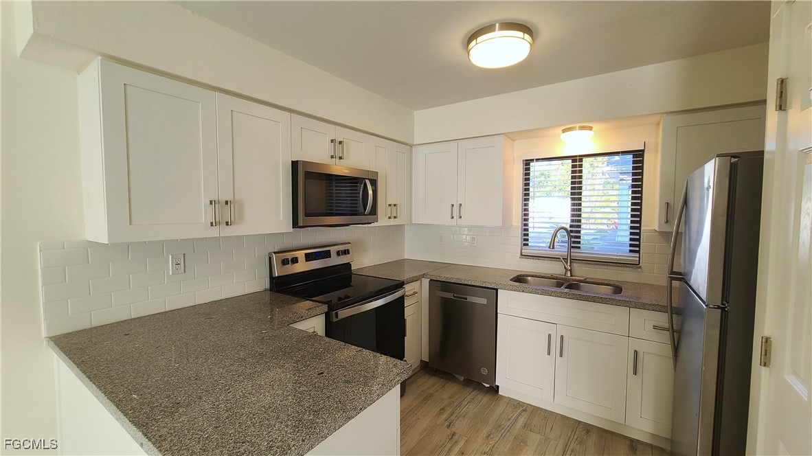 2610 Providence Street, Unit 1 Fort Myers, FL 33916 - Photo 4 of 16 a kitchen with stainless steel appliances granite countertop a sink stove and refrigerator