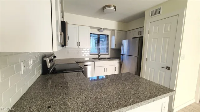 a kitchen with stainless steel appliances granite countertop a refrigerator and a sink