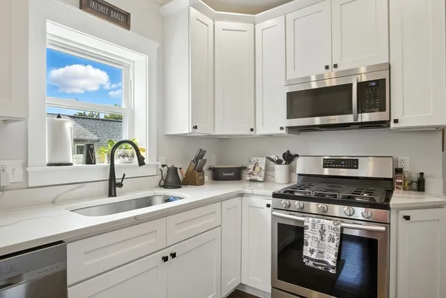 a kitchen with stainless steel appliances granite countertop a sink a stove and a microwave
