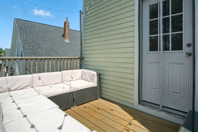 a view of a roof deck with couches and wooden floor