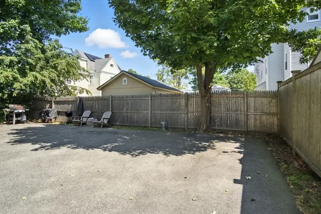 a view of a yard with wooden fence and a large tree