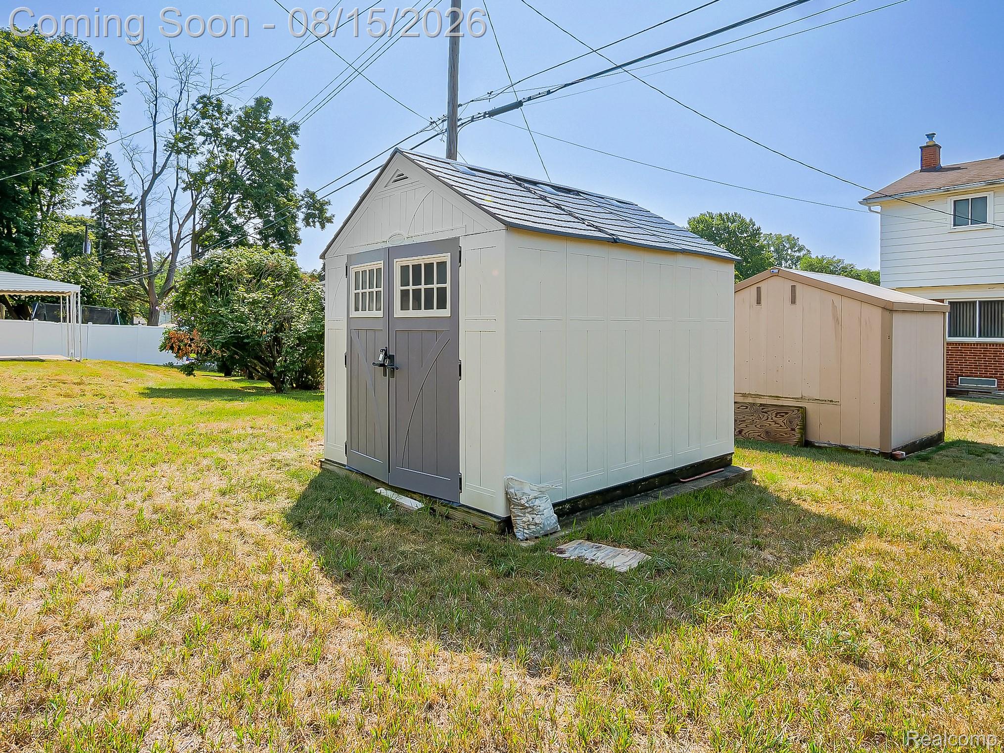 21131 Harvard Road Southfield, MI 48076 - Photo 28 of 33 Charming storage shed featuring a peaked metal roof, horizontal board-and-batten siding, and a sturdy wooden entry door
