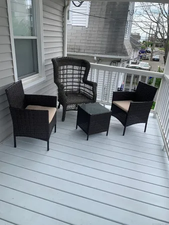 a roof deck with a couch and wooden floor