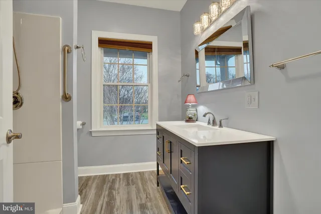 a bathroom with a granite countertop sink a toilet a mirror and vanity