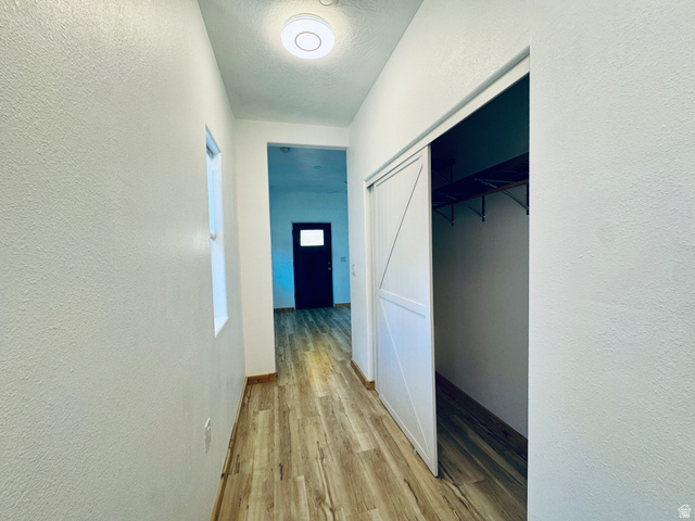 150 North 3050 East, Unit 4 St. George, UT 84790 - Photo 16 of 24 Hallway featuring wood-finish flooring, white walls, and a window providing natural light