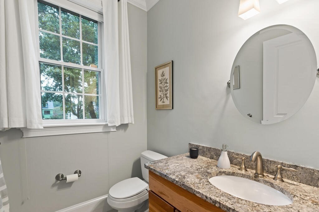 11 Kenilworth Road Arlington, MA 02476 - Photo 25 of 33 a bathroom with a granite countertop toilet a sink and a mirror