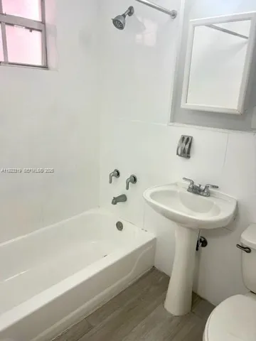 a white bath tub sitting next to a white sink