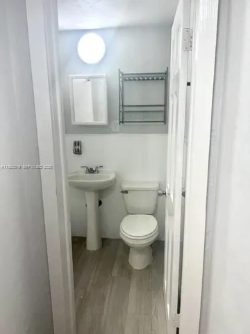 a bathroom with a toilet a sink and mirror