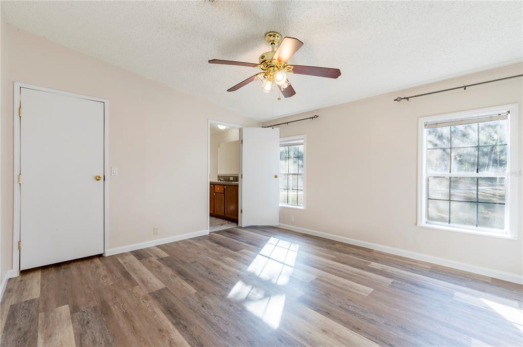 16314 Tiger Trail Spring Hill, FL 34610 - Photo 24 of 43 a view of an empty room with wooden floor and a window