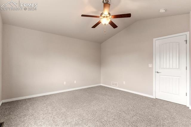 6227 Pilgrimage Road Colorado Springs, CO 80925 - Photo 15 of 38 Unfurnished room with ceiling fan, vaulted ceiling, and carpet flooring