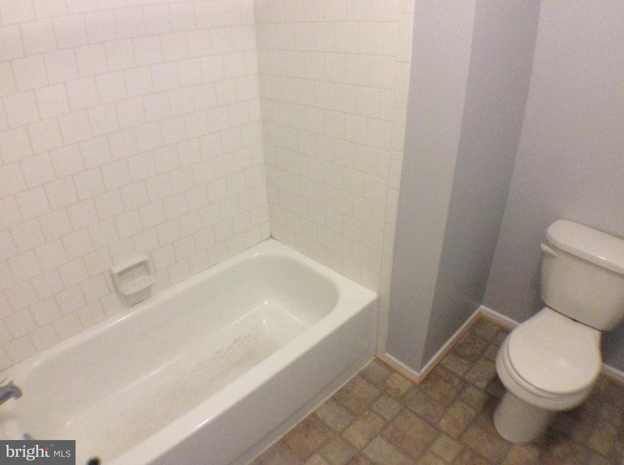 2021 Putnam Road Baltimore, MD 21227 - Photo 12 of 18 a white toilet sitting next to a bath tub
