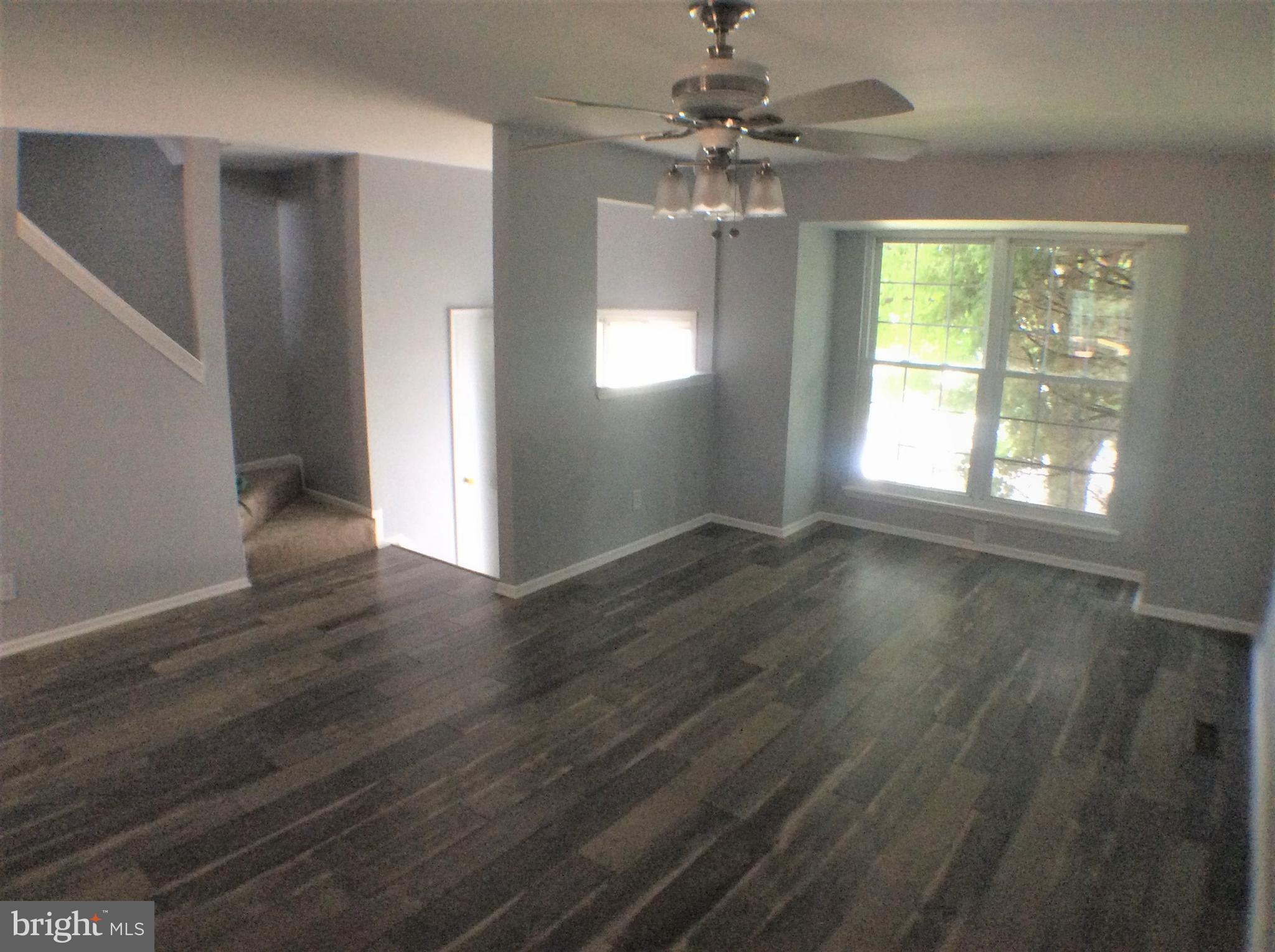2021 Putnam Road Baltimore, MD 21227 - Photo 4 of 18 a view of an empty room with wooden floor and a window