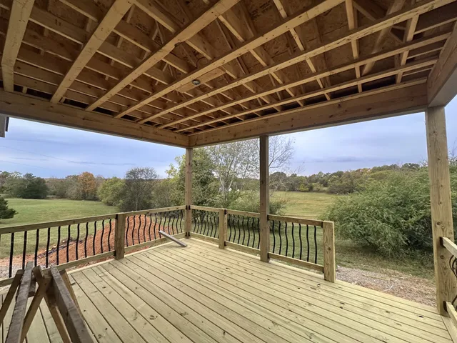 a view of a balcony with wooden floor next to a lake
