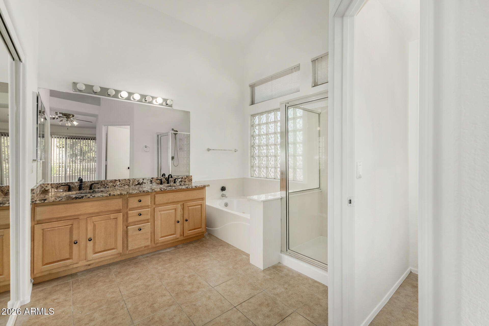 3962 East Agave Road Phoenix, AZ 85044 - Photo 20 of 54 a large bathroom with a granite countertop double vanity sink a mirror and a bathtub