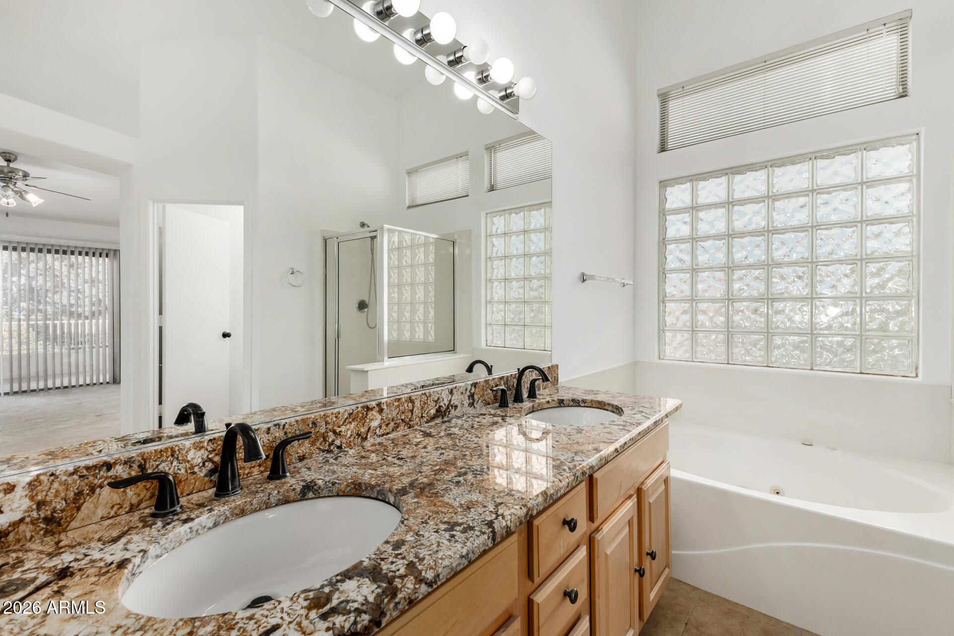 3962 East Agave Road Phoenix, AZ 85044 - Photo 21 of 54 a bathroom with a granite countertop sink a large mirror and a bathtub
