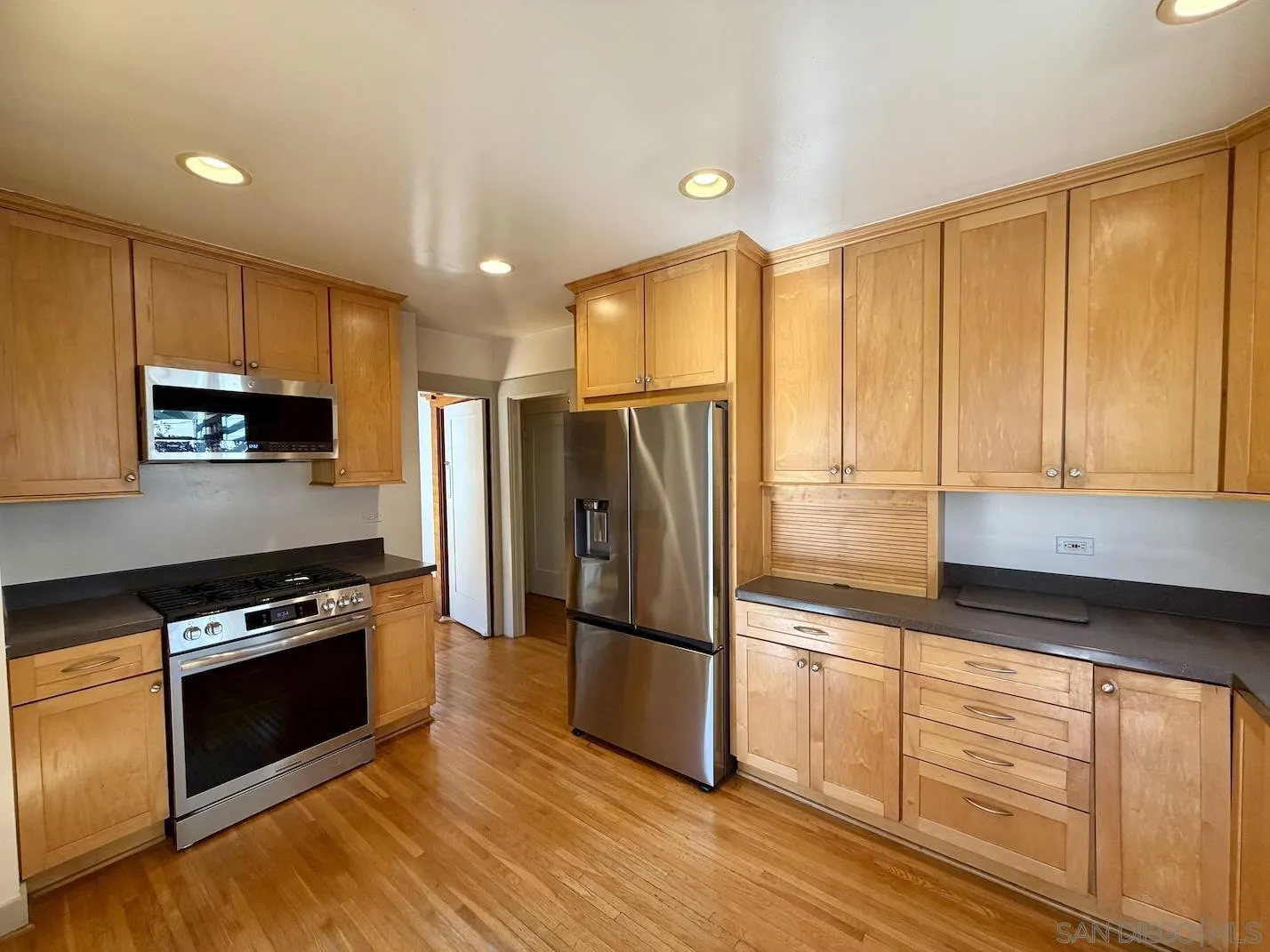 3917 Hawk Street San Diego, CA 92103 - Photo 15 of 40 a kitchen with stainless steel appliances granite countertop a refrigerator a stove a sink and a microwave