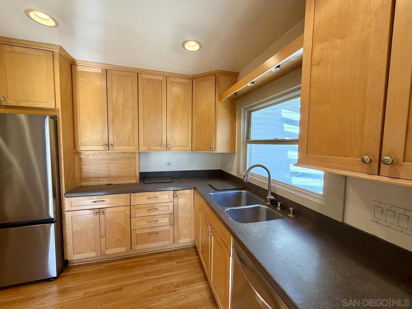 3917 Hawk Street San Diego, CA 92103 - Photo 16 of 40 a kitchen with stainless steel appliances granite countertop a sink refrigerator and cabinets