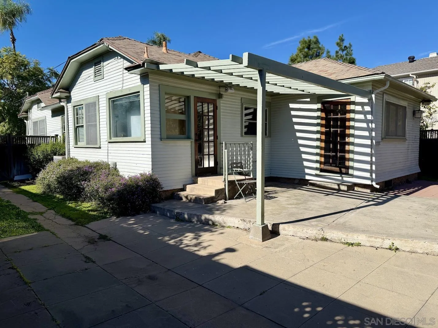 3917 Hawk Street San Diego, CA 92103 - Photo 37 of 40 a view of a white house with a small yard and potted plants