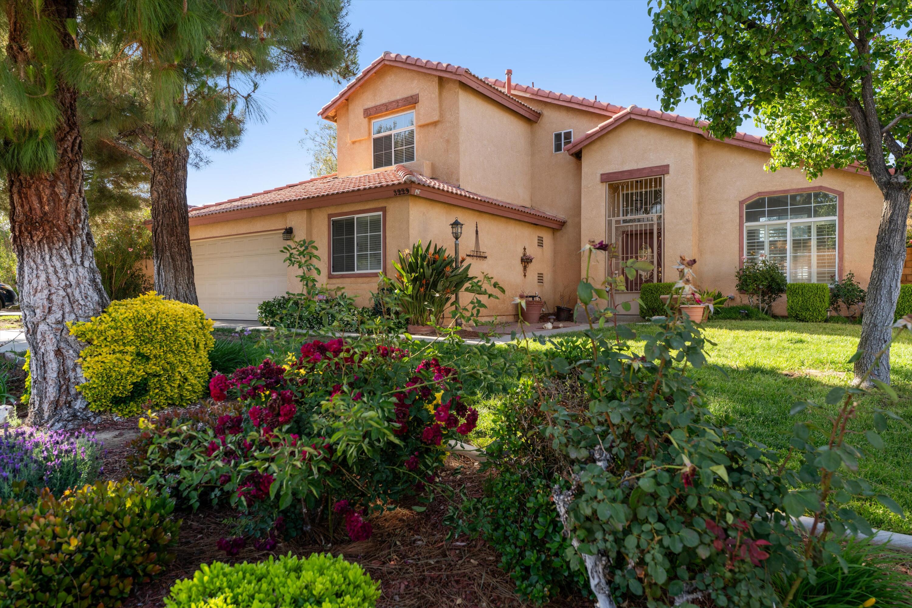 a front view of a house with a big yard and potted plants