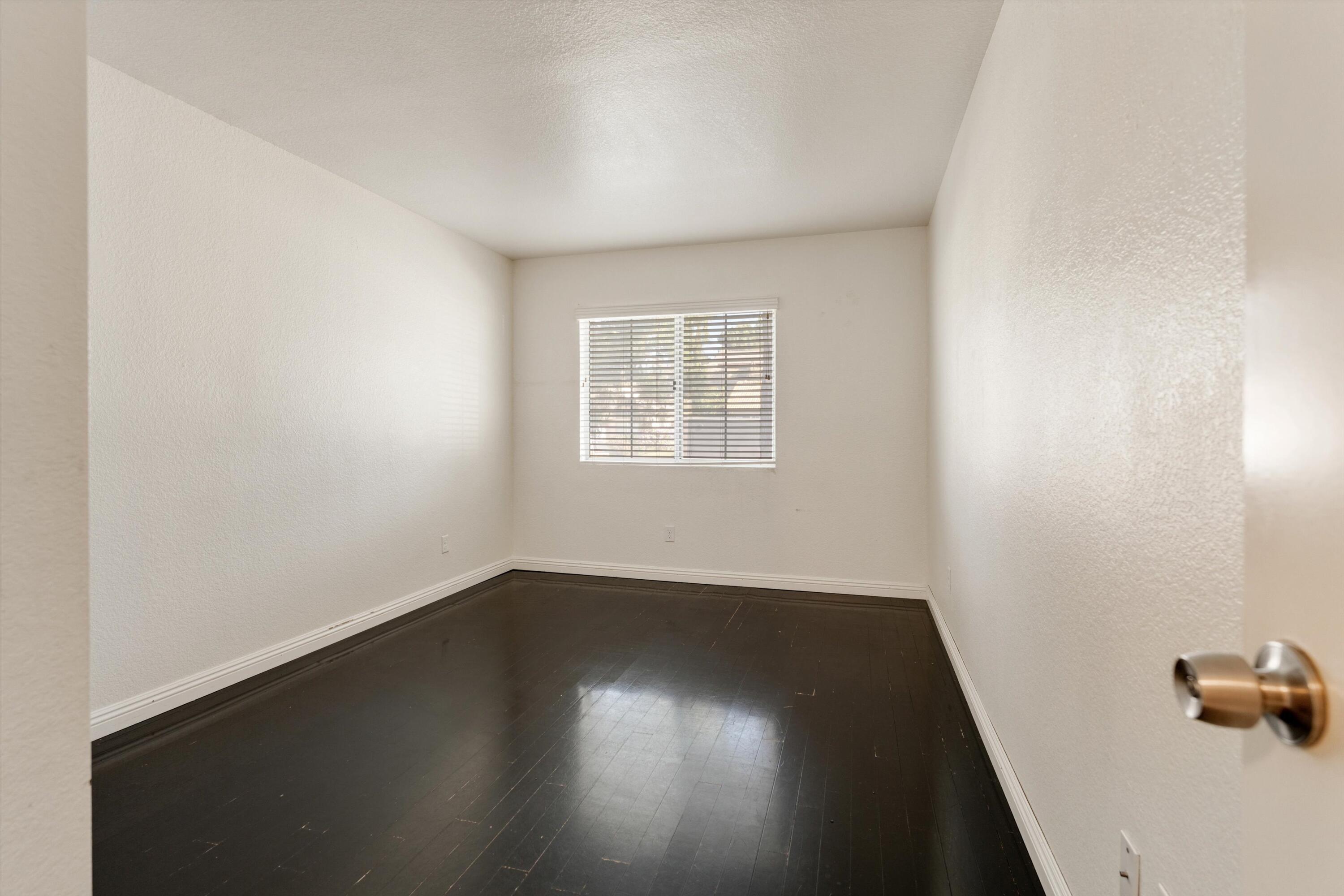 3229 Quarry Road Palmdale, CA 93550 - Photo 20 of 32 an empty room with wooden floor and windows