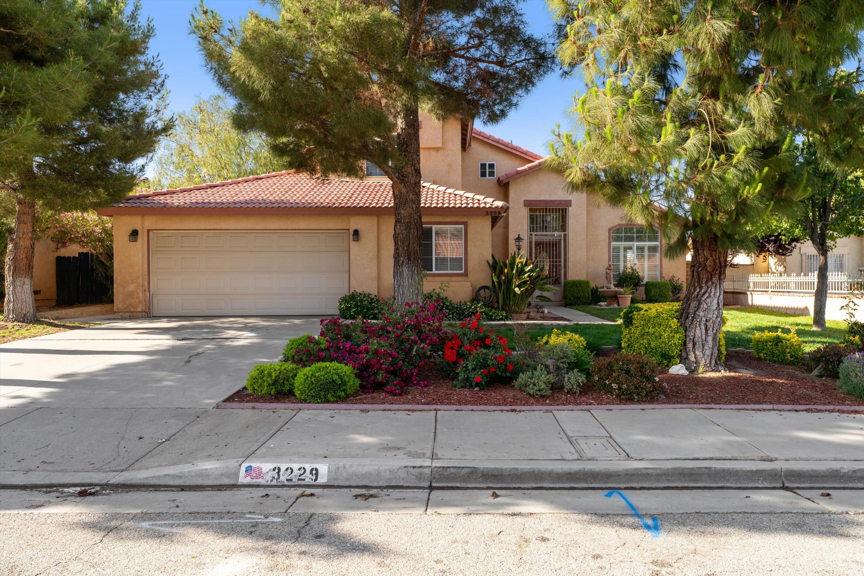 3229 Quarry Road Palmdale, CA 93550 - Photo 2 of 32 a front view of a house with a garden
