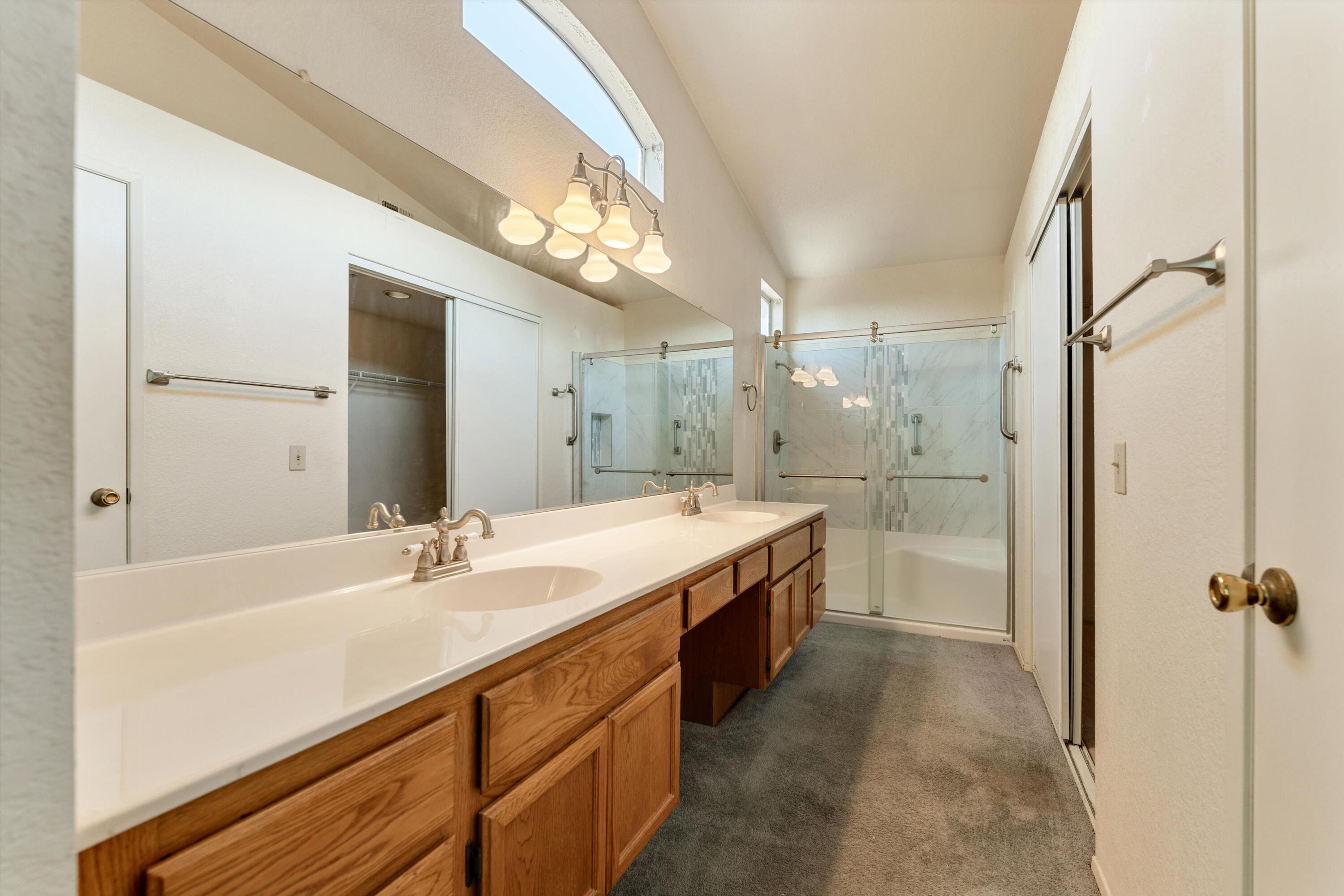 3229 Quarry Road Palmdale, CA 93550 - Photo 24 of 32 a bathroom with a double vanity sink a mirror and a bathtub