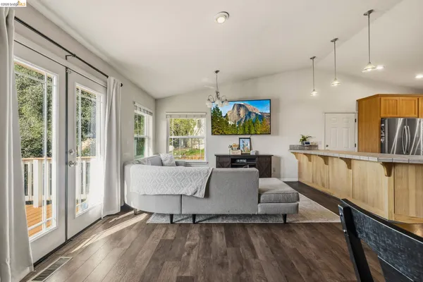 a living room with furniture a flat screen tv and a large window