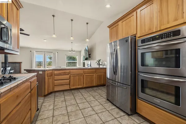 a kitchen with stainless steel appliances granite countertop a refrigerator a sink and a stove