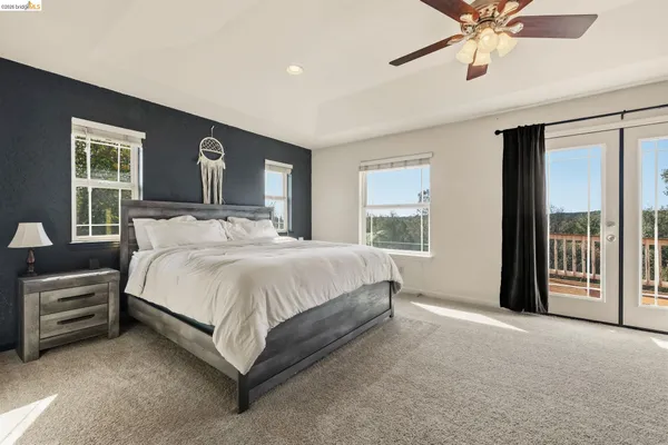 a bed sitting in a spacious bedroom next to a window