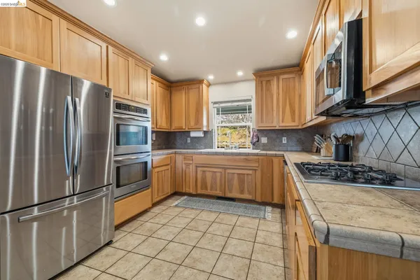 a kitchen with stainless steel appliances granite countertop a refrigerator sink and cabinets
