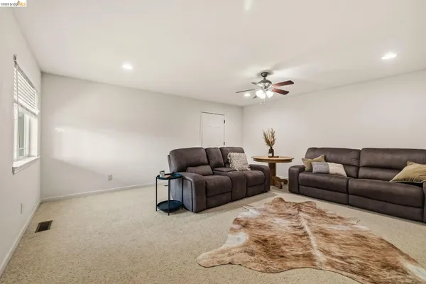 a living room with furniture and a ceiling fan