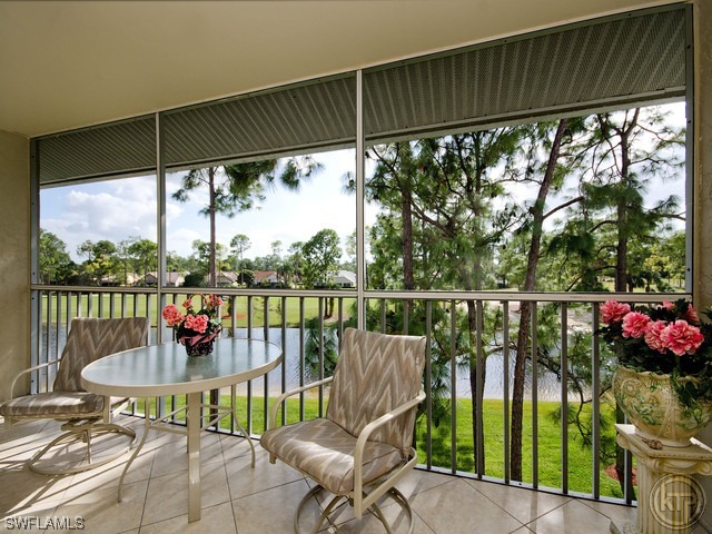 a roof deck with table and chairs and potted plants