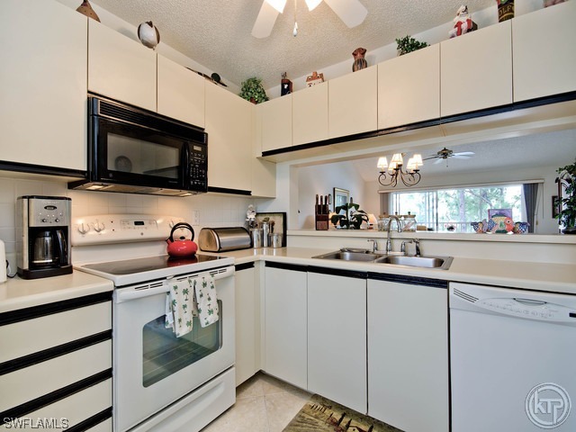 4580 Andover Way Naples, FL 34112 - Photo 7 of 12 a kitchen with stainless steel appliances kitchen island granite countertop a sink and cabinets